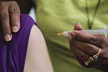 Nurse holding a needle about to vaccinate a patient