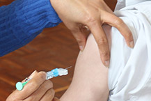 Nurse giving high school student a vaccine