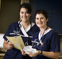 2 registered nurses looking over a patient file 