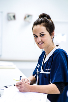 Emergency ward nurse smiling whilst filling in paperwork
